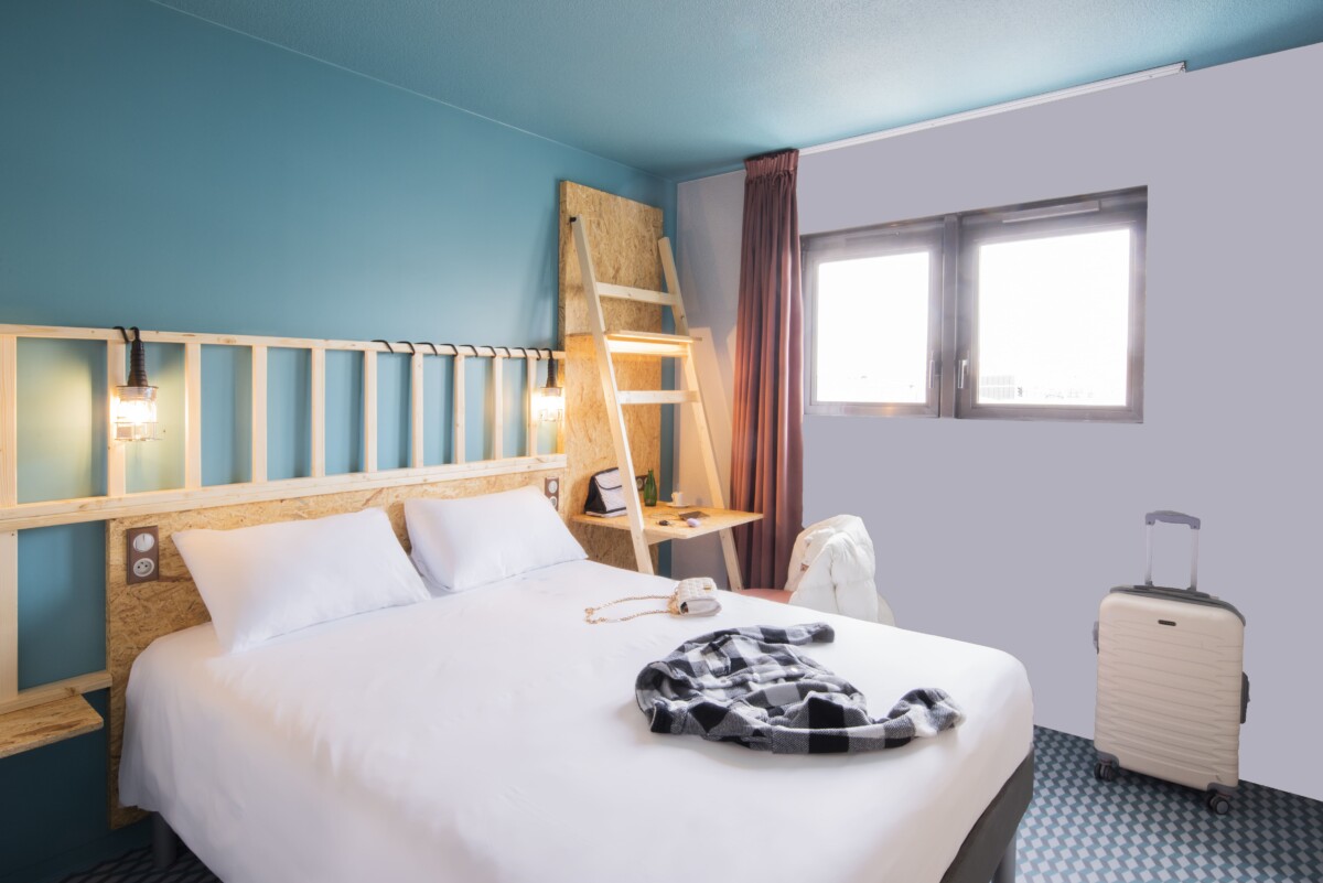 Chambre double spacieuse avec lit queen size, fauteuil design, plateau de courtoisie et bureau